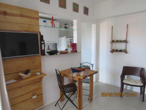 a living room with a table and a desk with a tv at Sahy - Aldeia dos Reis, Condado - Apartamento Quarto e Sala in Mangaratiba