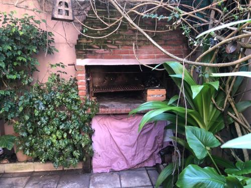 a brick wall with a purple sheet in a garden at varesse house in Mar del Plata