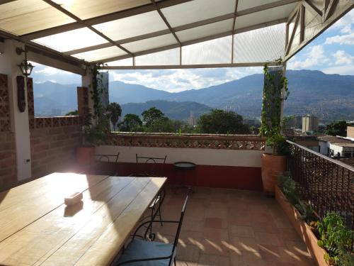 a patio with a wooden table and a view of mountains at Villa del Prado in Medellín