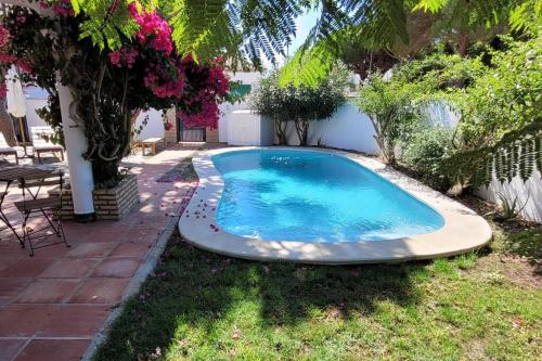 a swimming pool in the yard of a house at Chalet con piscina a 300 m del mar in Chiclana de la Frontera