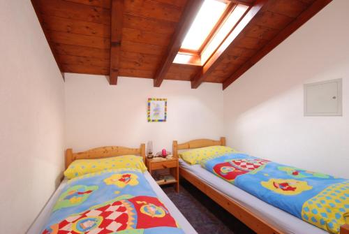 2 camas individuales en un dormitorio con tragaluz en Allegria, en Gambarogno