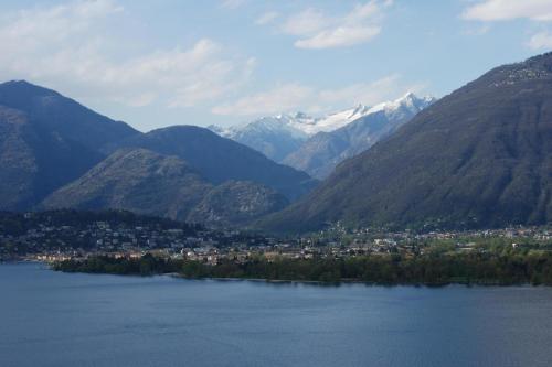 una ciudad en medio de un lago con montañas en Allegria, en Gambarogno