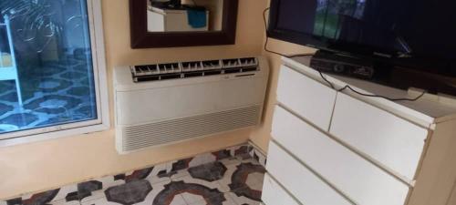 a living room with a tv and a window at Remarkable 4-Bed with air conditioning in Brikama in Brikama