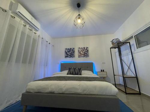 a bedroom with a large bed with a blue headboard at QUEEN of the dead sea by CROWN in Neve Zohar