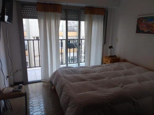 1 dormitorio con 1 cama grande y ventanas grandes en DPTO VICTORIA II en Mar del Plata