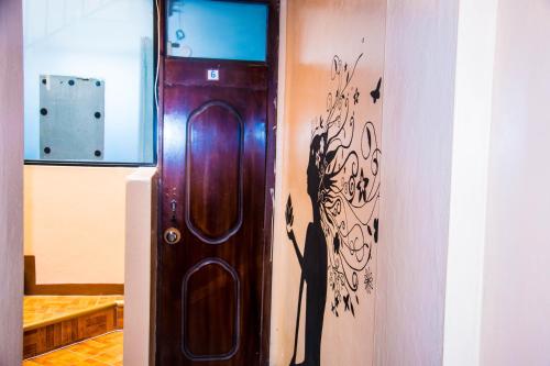 una puerta de madera con una pintura en la pared en La Posada Del Viajero, en Latacunga