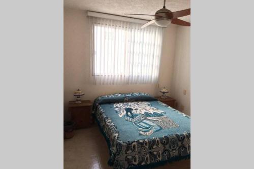 Schlafzimmer mit einem Bett und einem Deckenventilator in der Unterkunft Depa Frente al Mar en Acapulco Diamante in Acapulco