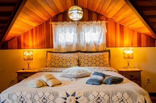 una camera con un letto con due cuscini sopra di Cantinho Pedra da Gávea a Visconde De Maua