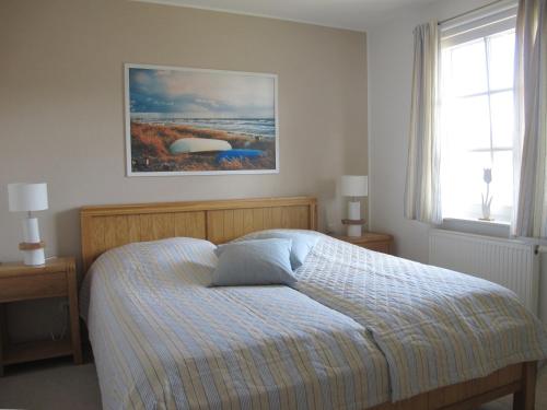 a bedroom with a bed and a painting on the wall at Wiesenstraße 55 Whg 1 - Meeresbrise in Zingst