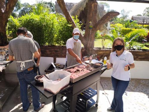 a group of people preparing food on a grill at Rancho Ecoturistico el Faro in La Mesa