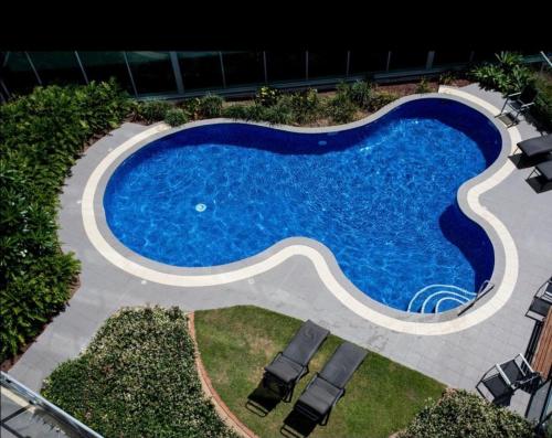 an overhead view of a swimming pool with chairs around it at Marina ocean view at Shores Southport in Gold Coast