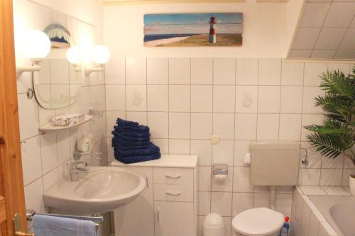 ein weißes Bad mit einem Waschbecken und einem WC in der Unterkunft "Im Eichenhof" Whg 1 - idyllische Dorflage Nähe Grömitz! Jetzt mit WLAN! in Schashagen