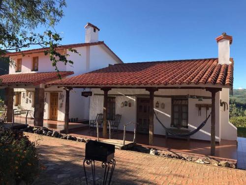 a large white house with a red roof at El Pueblito Hotel Boutique in Samaipata