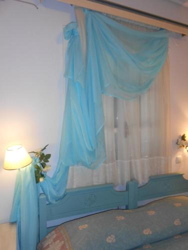 a bedroom with a blue bed with a window at Villa Ianthia in Galaxidhion
