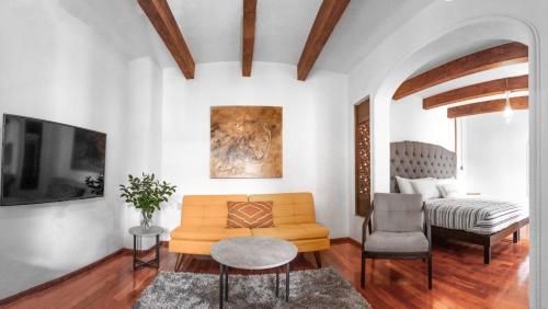 ein Wohnzimmer mit einem Sofa und einem Bett in der Unterkunft Bello atardecer - hotel boutique in Tequisquiapan