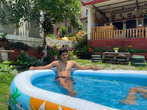 a man in a swimming pool in a backyard at Birds Nest Hostel in Kathmandu