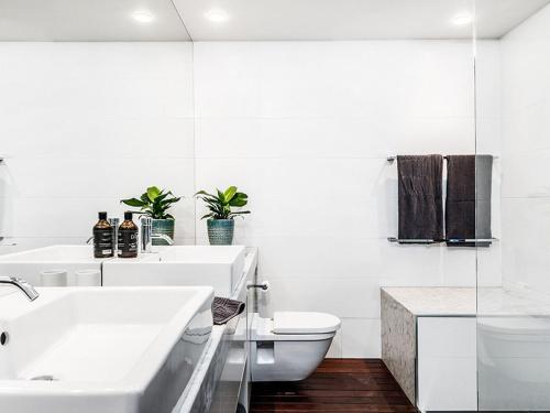 a white bathroom with a sink and a toilet at On The Bay II in Byron Bay