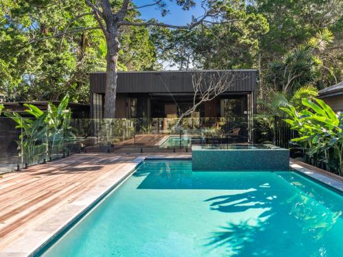 a swimming pool in the backyard of a home with a house at Tallowood - luxury beach house with pool & studio in Suffolk Park