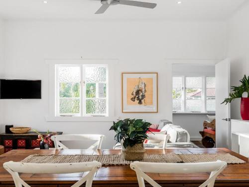 a dining room with a table and chairs at Alkira - Boutique cottage - Walk to Clarkes Beach in Byron Bay