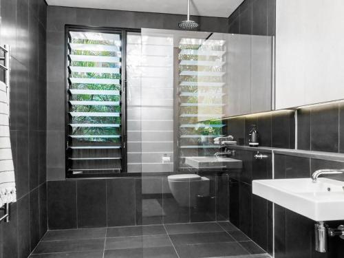 a black and white bathroom with a toilet and a sink at Tallowood - luxury beach house with pool & studio in Suffolk Park