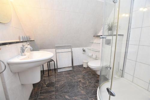 La salle de bains est pourvue d'un lavabo, de toilettes et d'une douche. dans l'établissement Yachthafenhöh Whg4, à Grömitz
