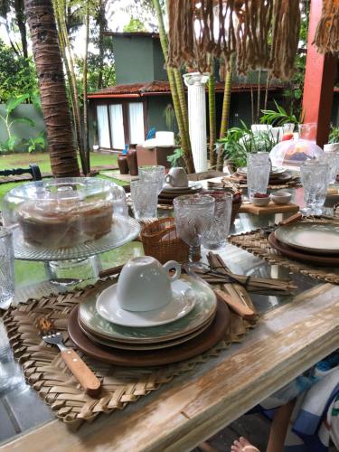 uma mesa de madeira com pratos e pratos em Kûara Pipa em Pipa