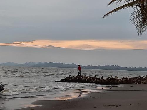 a man standing on a boat in the water at Cabañas El Olimpo in Necoclí