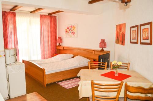 1 dormitorio con 1 cama, mesa y sillas en Ferienhof Frohne - Zum wilden Eber, en Merzen