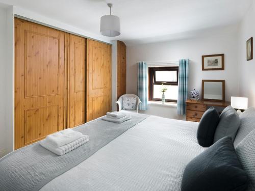 CaldbeckにあるEllwood Houseの大きなベッドとタオル2枚のある寝室