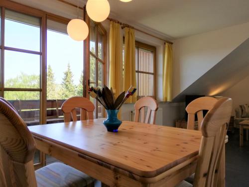 una mesa de comedor con sillas y un jarrón. en Harzwellness, en Altenau