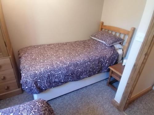 a small bedroom with a bed and a table at The Barn in Long Sutton