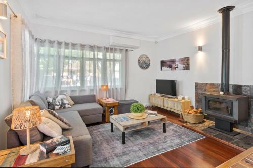 a living room with a couch and a fireplace at Green House in Busselton