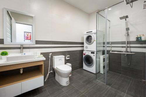 a bathroom with a toilet and a washing machine at Arrive Hotel & Apartment in Danang
