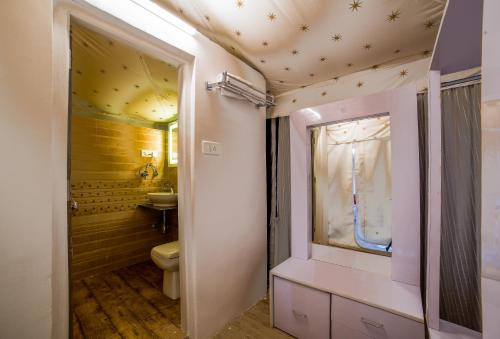 a bathroom with a toilet and a sink at Dawn N Dusk Glamping tents with quintessential valley view in Chail