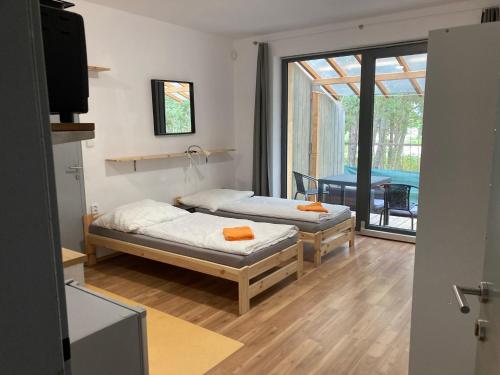 Račice的住宿－KuK Račice - mini apartman，一张桌子和一个阳台,配有两张床。