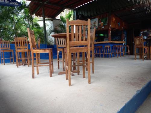 a group of wooden chairs sitting in front of a table at La Cascada Hostel & Restaurant in Rivas