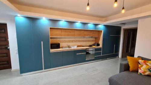 Zander Home Apartment في بوستين: مطبخ به دواليب زرقاء وجدار ازرق