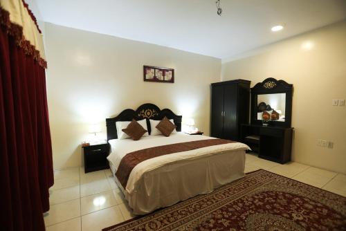 una camera con un grande letto e uno specchio di العييري للشقق المخدومة الدمام Al Eairy Serviced Apartments Dammam 7 a Dammam