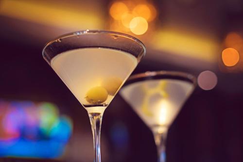 two martini glasses with a olive in them at Premier Resort Mpongo Private Game Reserve in Macleantown