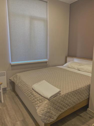a small bedroom with a bed with a window at Prestige Apartments Kalnyshevskogo in Dnipro