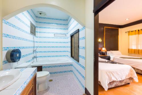 een badkamer met een blauwe en witte streepmuur bij เฮือนคำรีสอร์ท บูติค โฮเทล แม่สาย เชียงราย in Chiang Rai