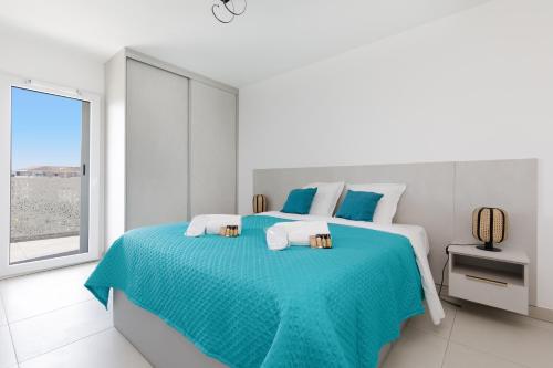 - une chambre blanche avec un lit bleu et une fenêtre dans l'établissement Mandelieu 404 YourHostHelper, à Mandelieu-la-Napoule