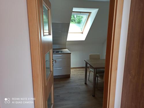 a small kitchen with a table and a window at Apartmá Na Lipně in Horní Planá