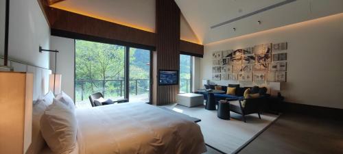 a bedroom with a large bed and a living room at Ahn Lan Xinchang in Xinchang