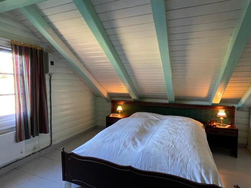 a bedroom with a large bed in a attic at Olastugu in Ål