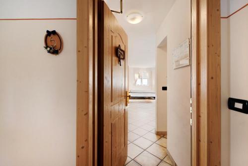 um corredor com uma porta de madeira e um piso de azulejo em Residence Montebel Bilocale em Tesero