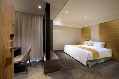 花蓮市的住宿－成旅晶贊飯店-花蓮假期，酒店客房配有一张床、一张桌子和一把椅子。