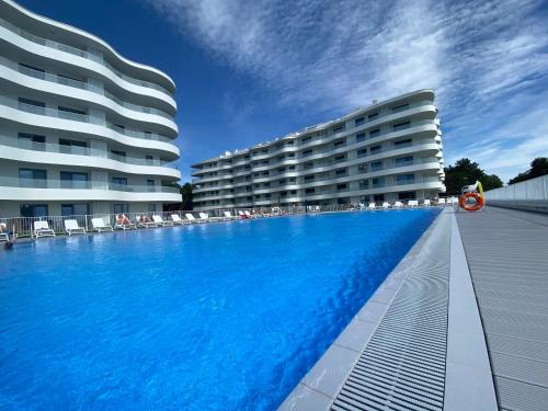 une grande piscine devant un immeuble dans l'établissement Lake View Sea Apartment Rogowo Pearl, à Rogowo