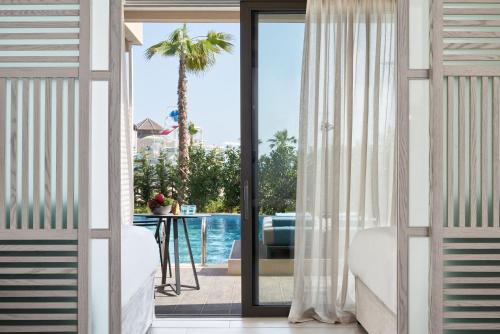 a room with a sliding glass door with a view of a pool at Mare Ayia Napa in Ayia Napa