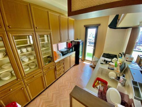 a kitchen with wooden cabinets and a counter top at Hotel EL Utsunomiya 7 free parking in Utsunomiya